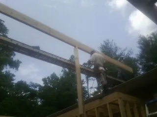 Carpenter setting a ridge beam over a new addition frame — Ice Dam Removal by Roofing Brothers in Myerstown