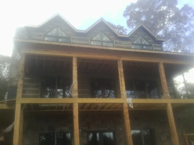 Dormers and porch framing on a large log home under construction — Roof Coating work by our crew in Myerstown